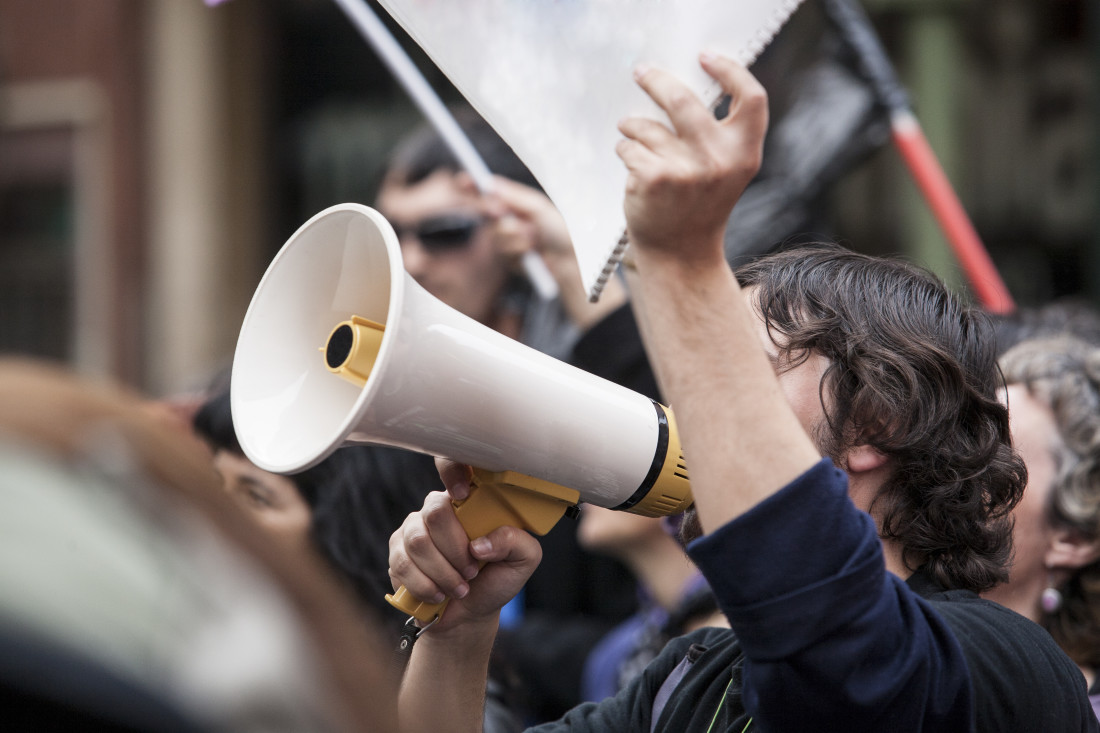 Demonstrator with Megaphone and Notebook Protesting