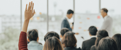 Person raising hand in a work training meeting